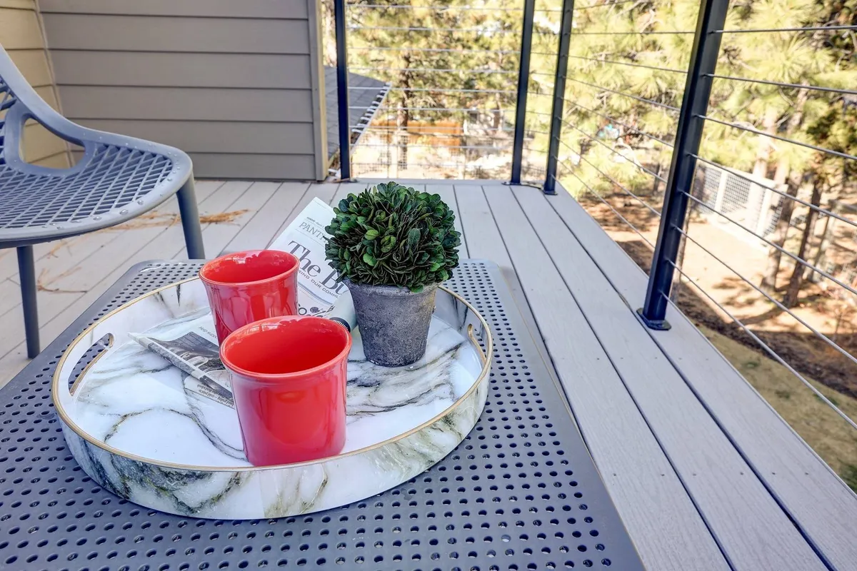 A small outdoor patio or deck setup featuring a marble tray with red cups and a small potted plant, inviting guests to enjoy drinks, quiet moments, or casual gatherings outdoors. The scene conveys relaxation and the enjoyment of the natural surroundings.